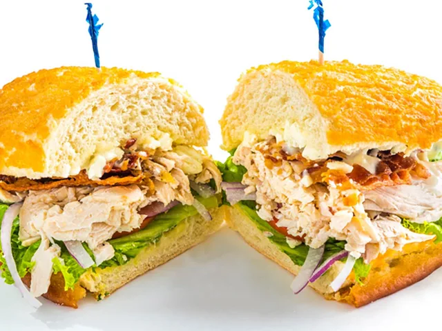 Chicken Cobb sandwich with bacon and blue cheese crumbles, halved