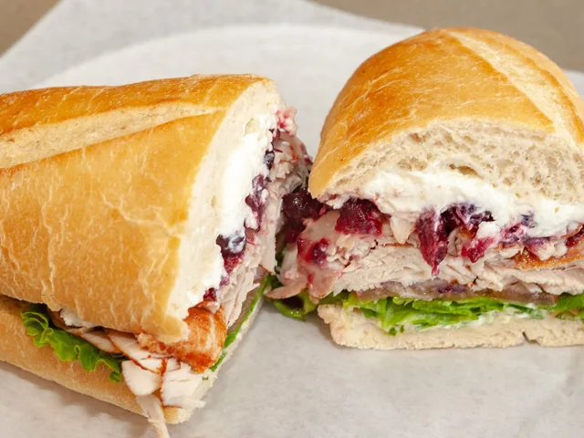 Giving Thanks sandwich with turkey, cream cheese and cranberry sauce, halved