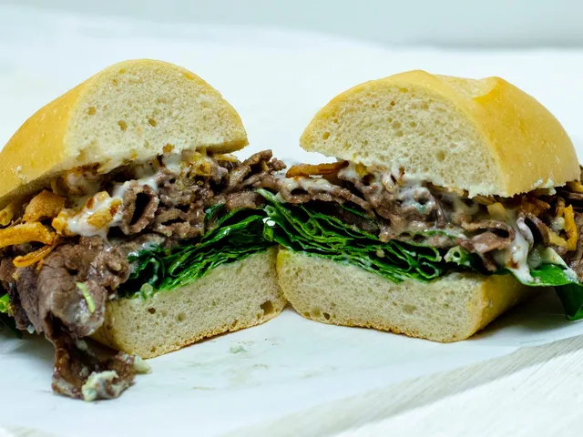 Tri Tip Black and Blue sandwich with blue cheese crumbles and spinach, halved